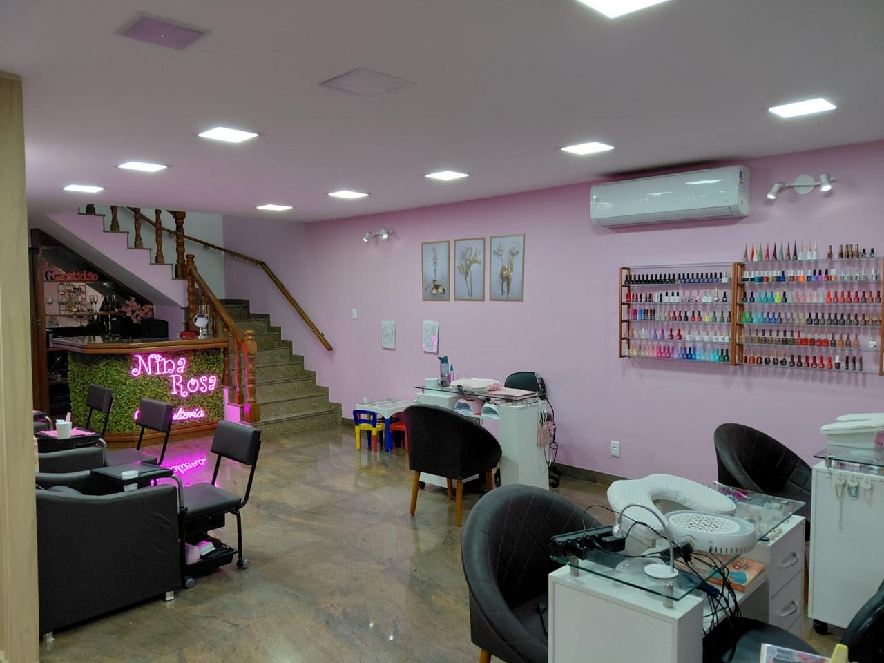 Nail bar com parede de esmaltes e balcão em neon da Nina Rosa