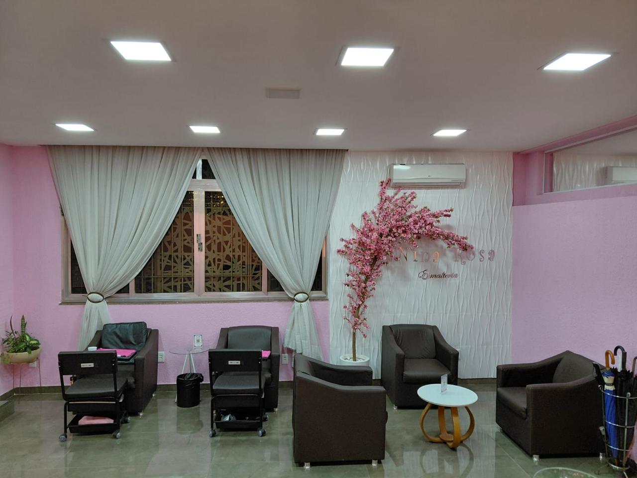 Sala de espera com poltronas e árvore decorativa rosa