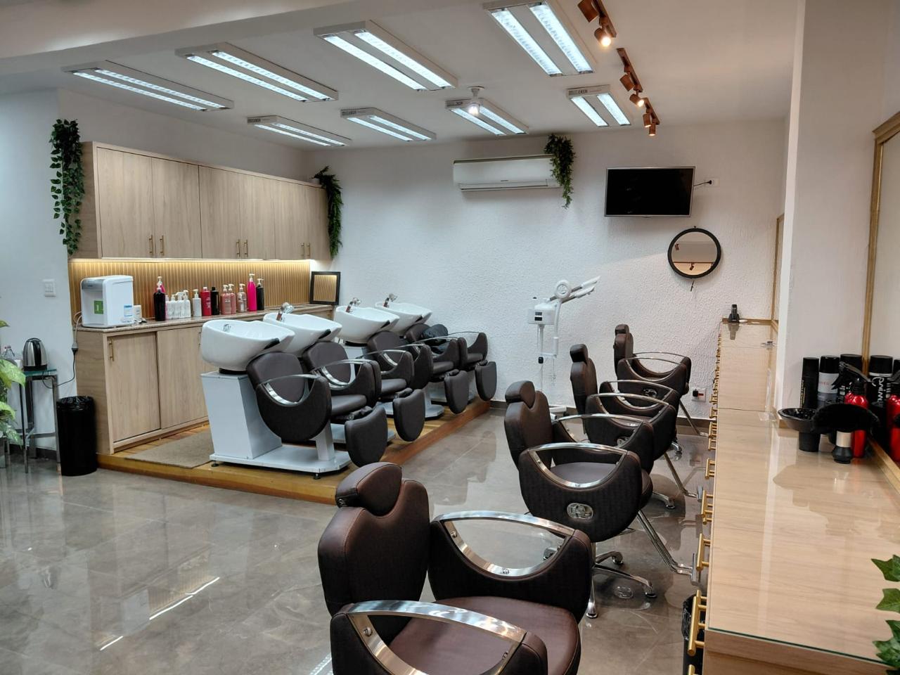 Salão de cabelo com lavatórios, cadeiras e bancada iluminada
